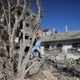 Palestinian boy plays on May 24, 2021 next to buildings damaged damaged by Israeli air strikes earlier this month in Beit Hanoun in the northern Gaza Strip.